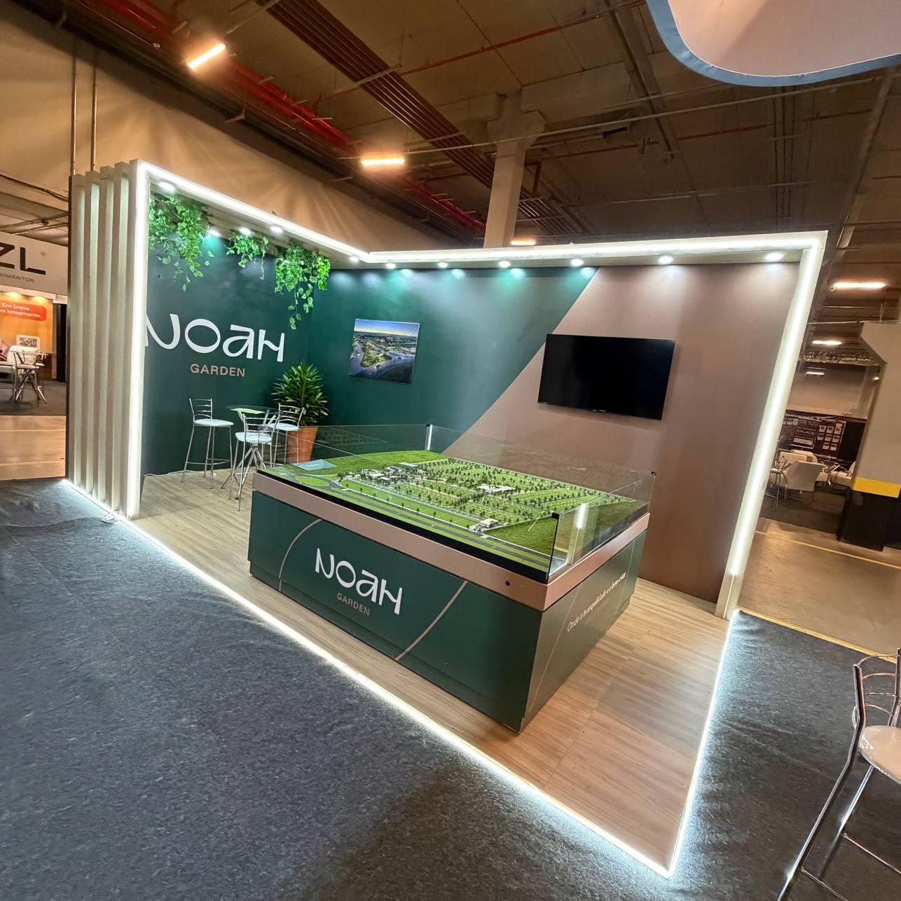 Estande de lançamento imobiliário com mesa de maquete e LED
